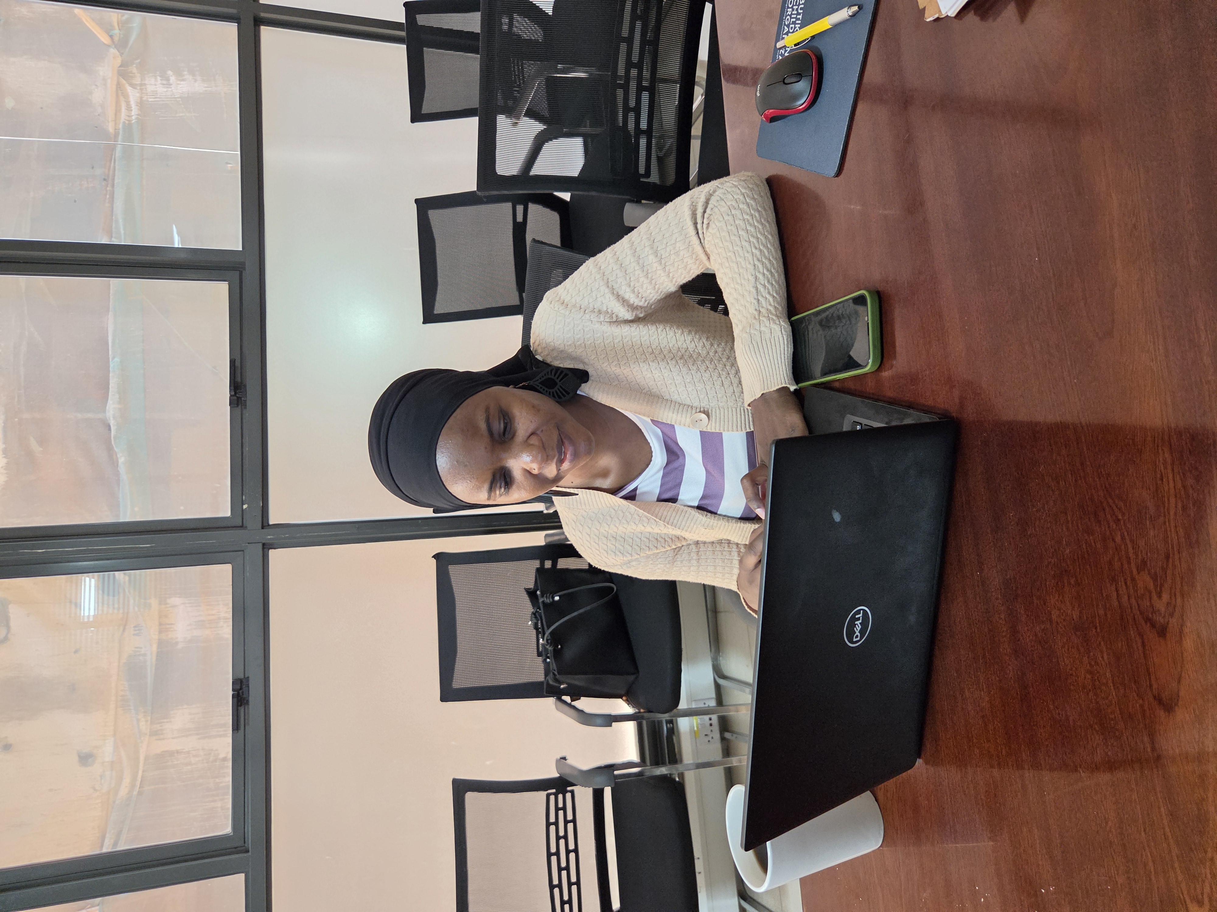 A participant at The Promise Standard School deployment readiness meeting, seated at a conference table with a laptop.